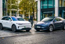 Leapmotor C10 vs Tesla Model Y side by side on a modern UK city street, comparing two electric SUVs